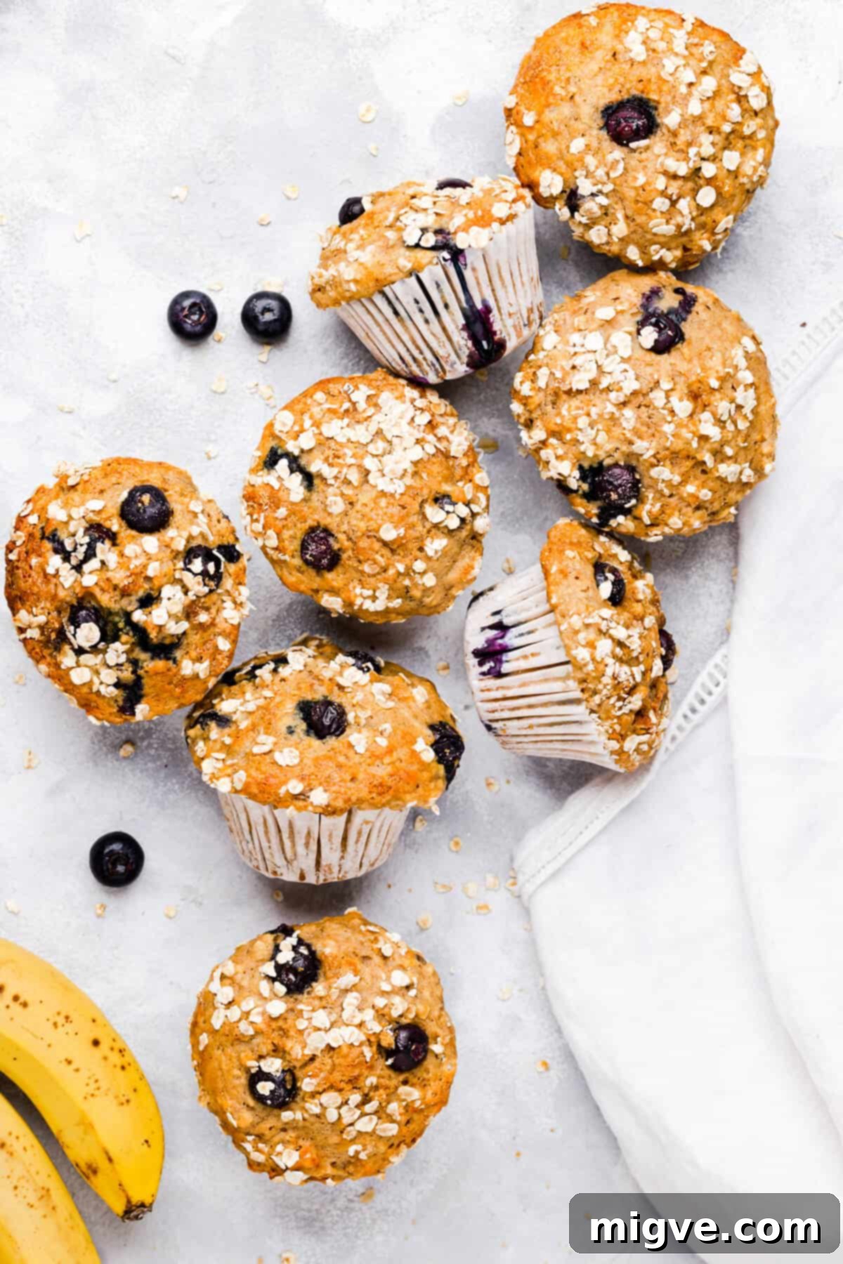 Overhead view of a vibrant arrangement of fresh bananas and blueberries, highlighting the key ingredients for these delicious muffins.