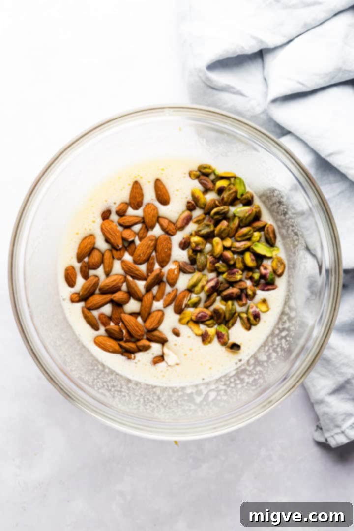 top view of a bowl with pistachios and almonds and whipped eggs