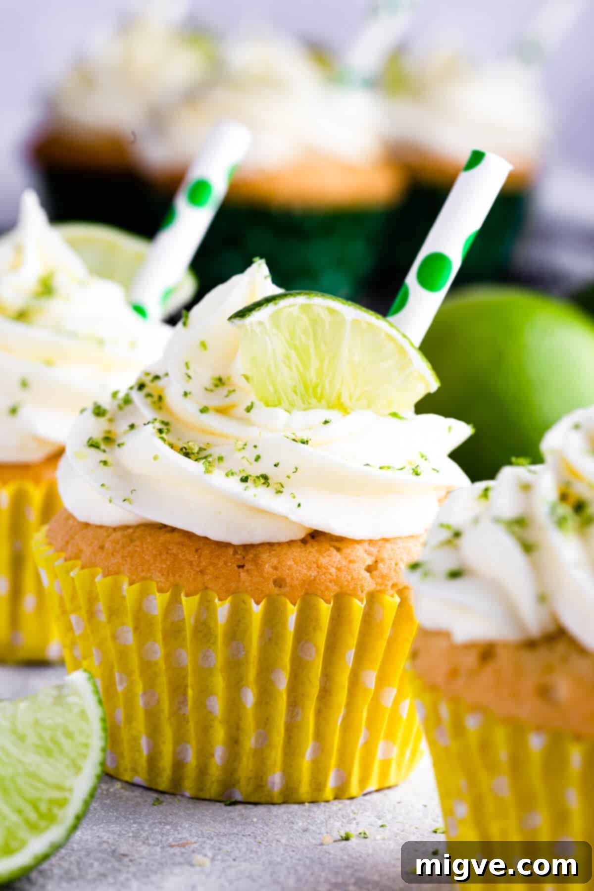 Close-up of a perfectly baked Gin and Tonic Cupcake in a vibrant yellow paper case, showcasing its soft texture and inviting appeal.