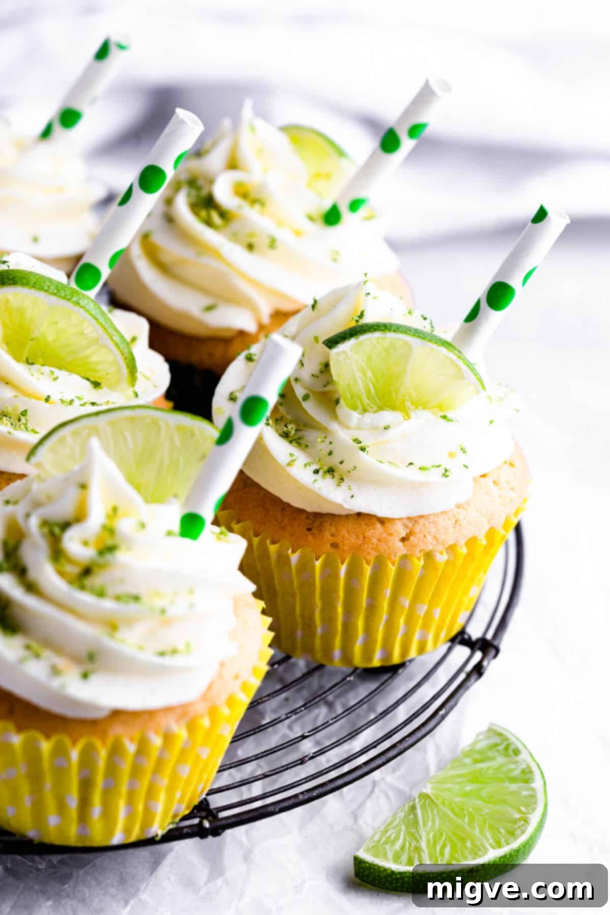 Side view of freshly baked Gin and Tonic Cupcakes cooling on a metal wire rack, waiting for their luscious frosting.