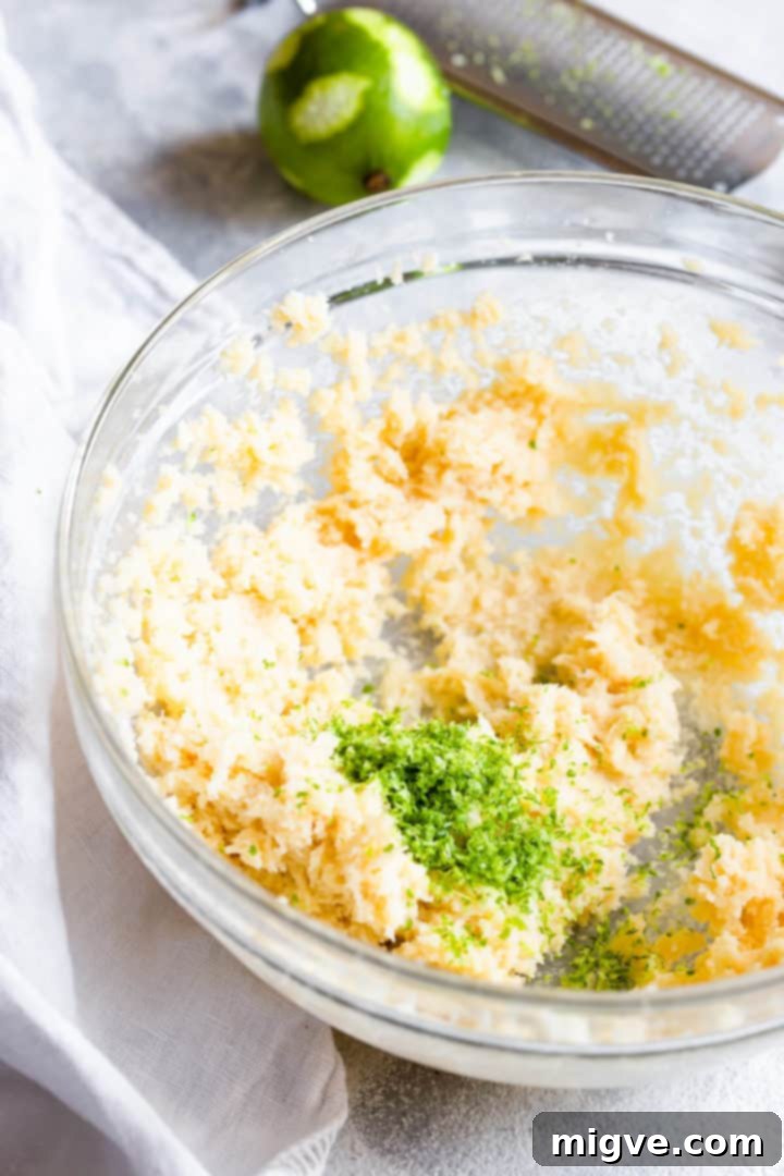 Side close-up of a bowl showing whipped butter and the vibrant addition of lime zest.