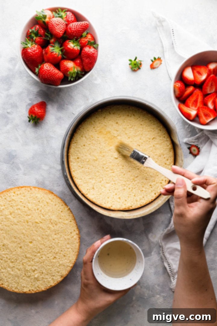 overhead shot of sponge disc being brushed with syrup