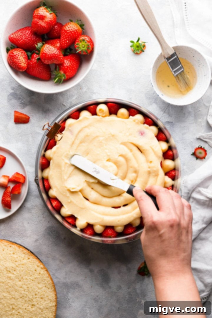 overhead shot of cake filling being spread with spatula
