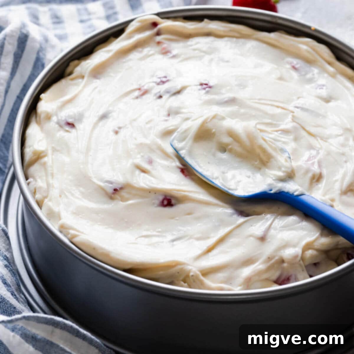 Velvet Strawberry White Chocolate Cheesecake 11 side close up at a cake tin filled with strawberry cheesecake batter