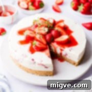 Velvet Strawberry White Chocolate Cheesecake 16 45 degree angle view of strawberry white chocolate cheesecake with a slice cut out