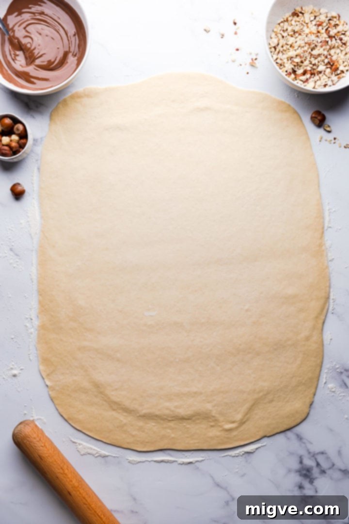 Top-down view of babka dough perfectly rolled out into a large rectangle, ready for filling.