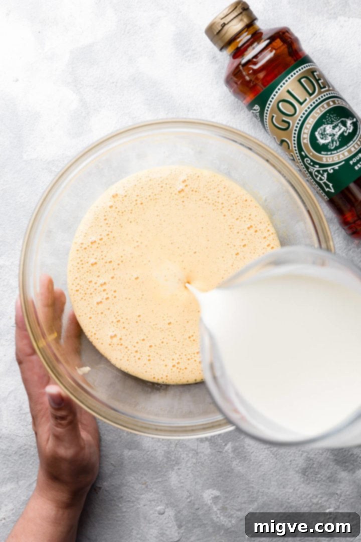 top view of cream being poured into the bowl with egg mixture