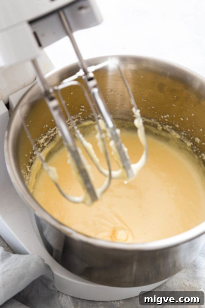 A 45-degree angle view of smooth, pale, and fluffy cake batter in a mixing bowl after eggs have been incorporated.