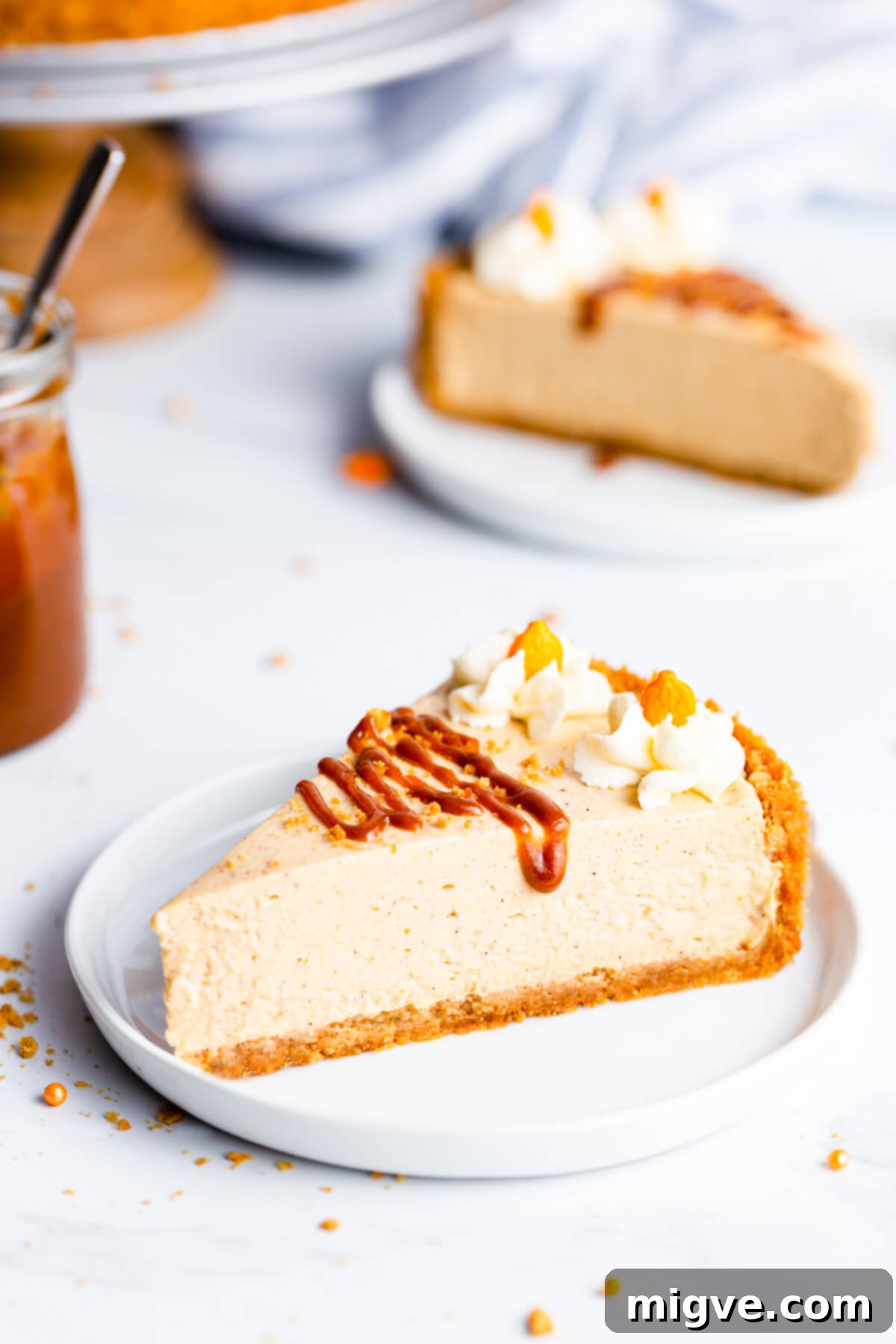 45 degree angle super close up at a single slice of pumpkin cheesecake drizzled with salted caramel