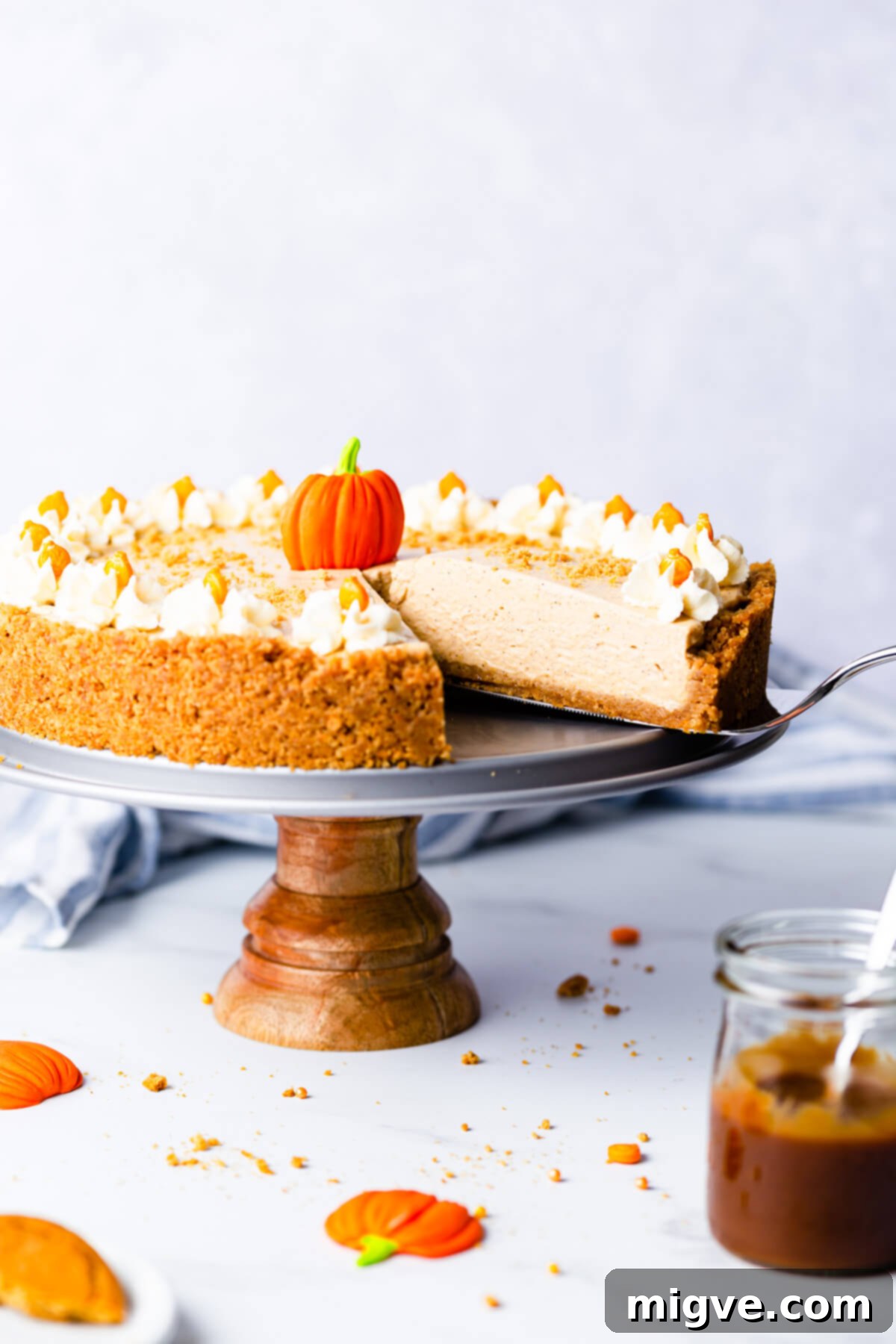 side angle close up at a slice of pumpkin cheesecake being lifted on a cake lifter