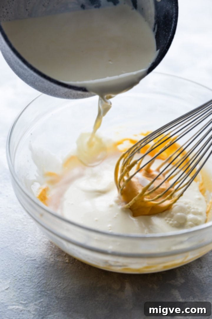Spiced Apple Crumble Cupcakes 16 side close up at hot cream being poured into the bowl with custard paste