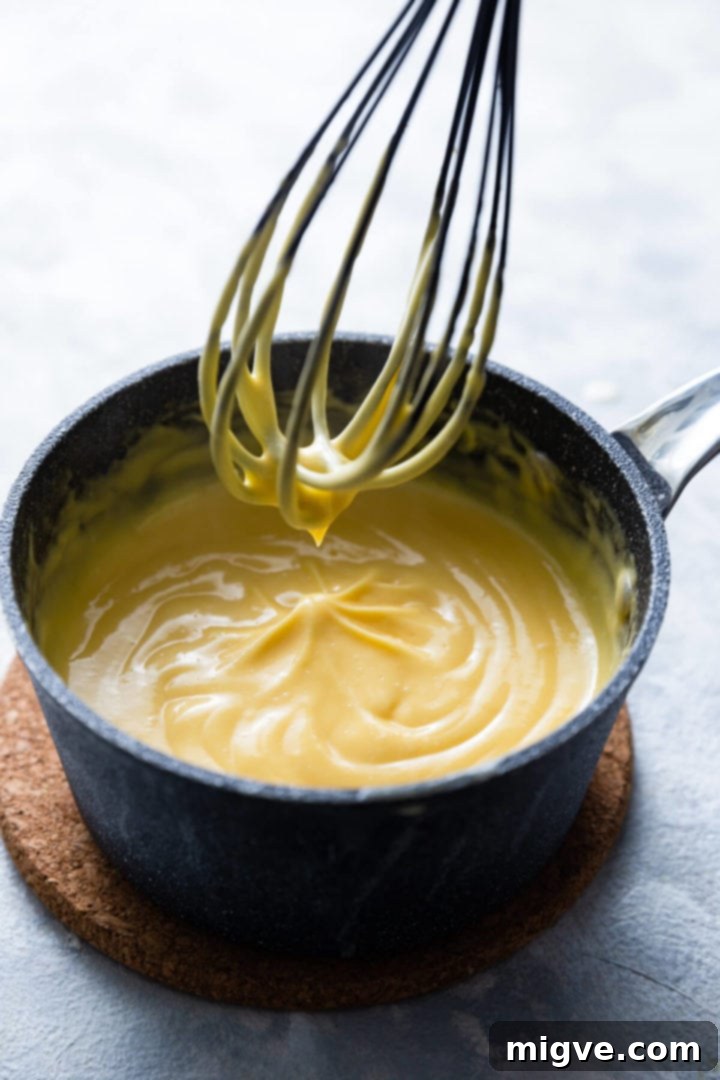 Spiced Apple Crumble Cupcakes 17 45 degree angle shot of a saucepan with custard cream