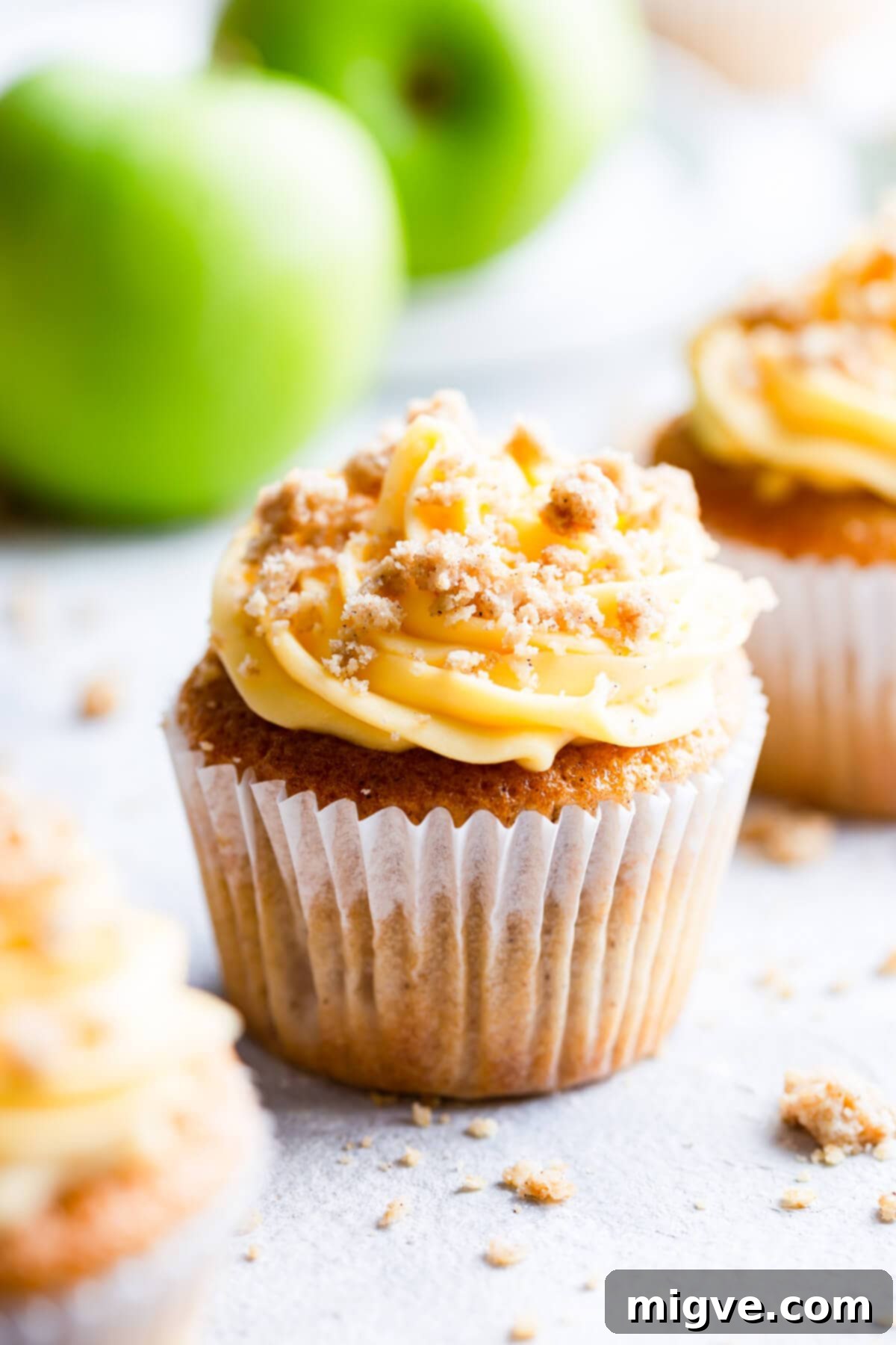 Spiced Apple Crumble Cupcakes 20 side super close up at an apple crumble cupcake with some green apples in the back