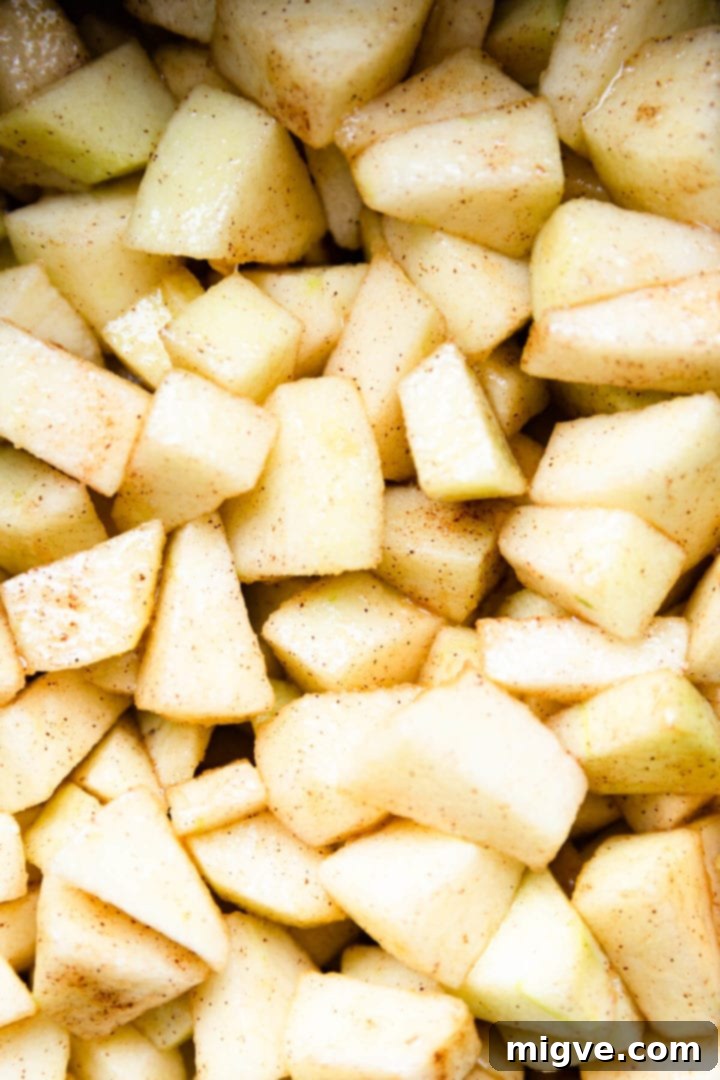 Spiced Apple Crumble Cupcakes 7 top view close up of chopped apples covered in butter, sugar and cinnamon