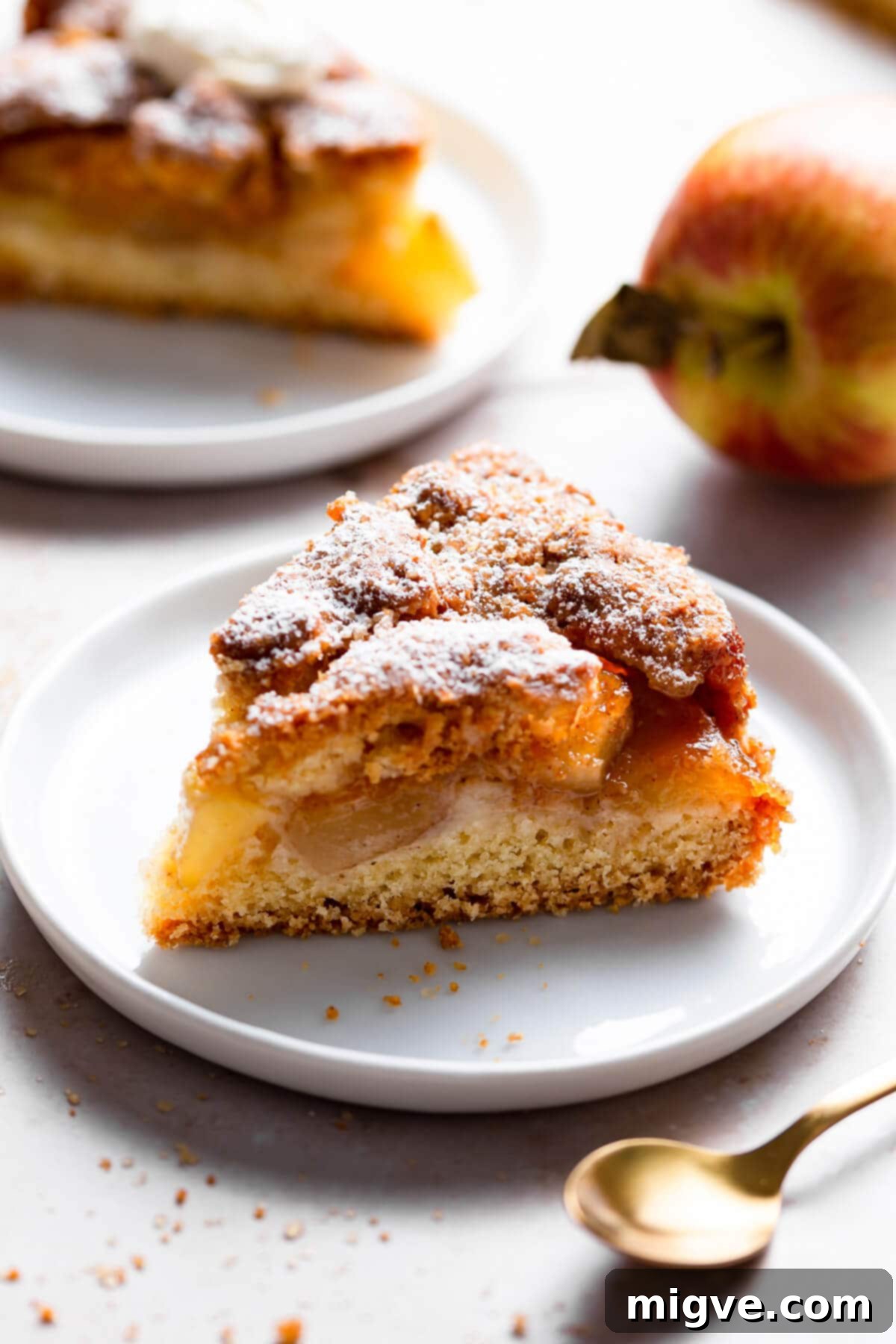 No-Fuss Apple Cake 11 side super close up at an individual slice of an apple cake on a small plate, showing the apple layers