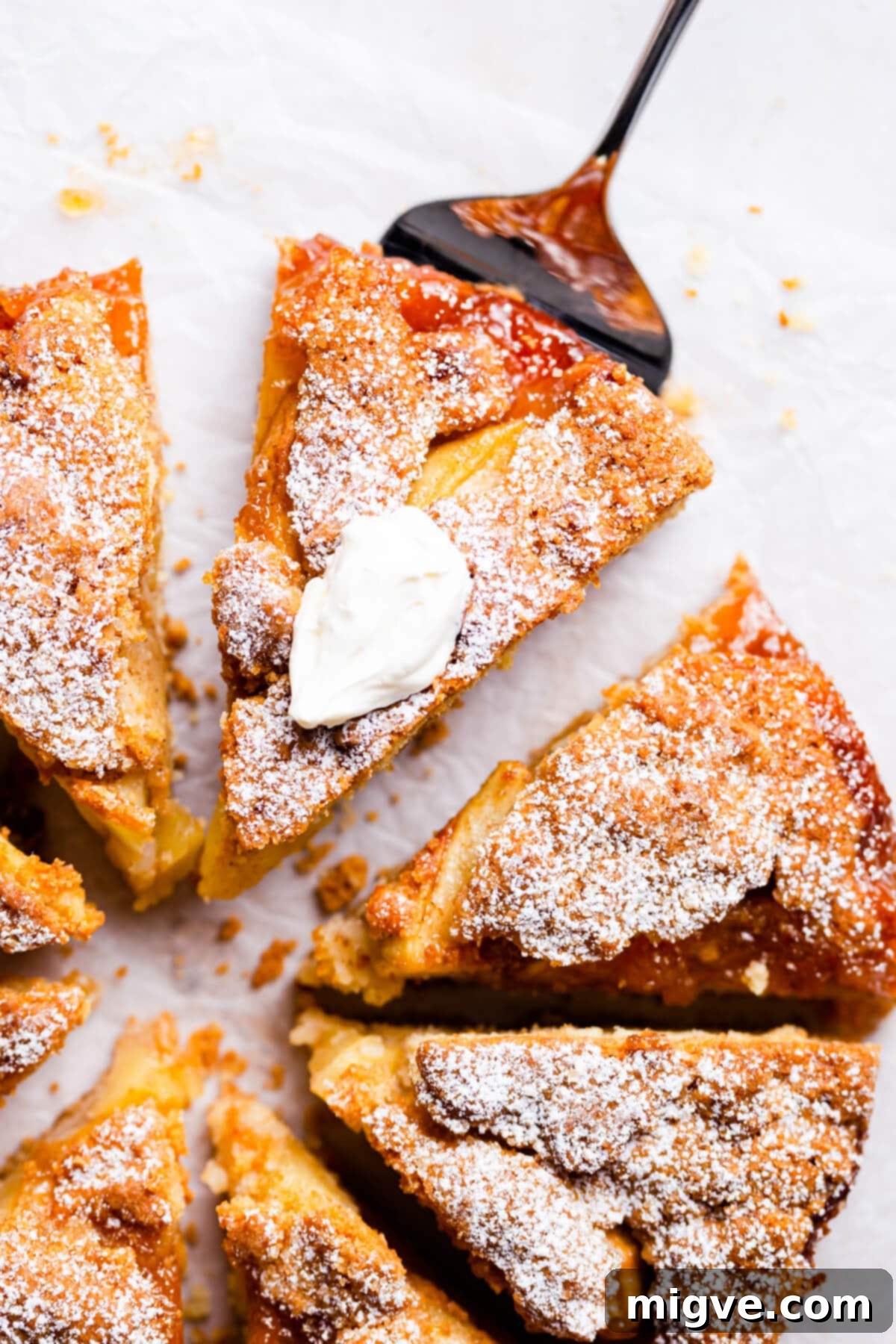 No-Fuss Apple Cake 12 top view super close up at a slice of an apple cake topped with whipped cream, ready to be enjoyed