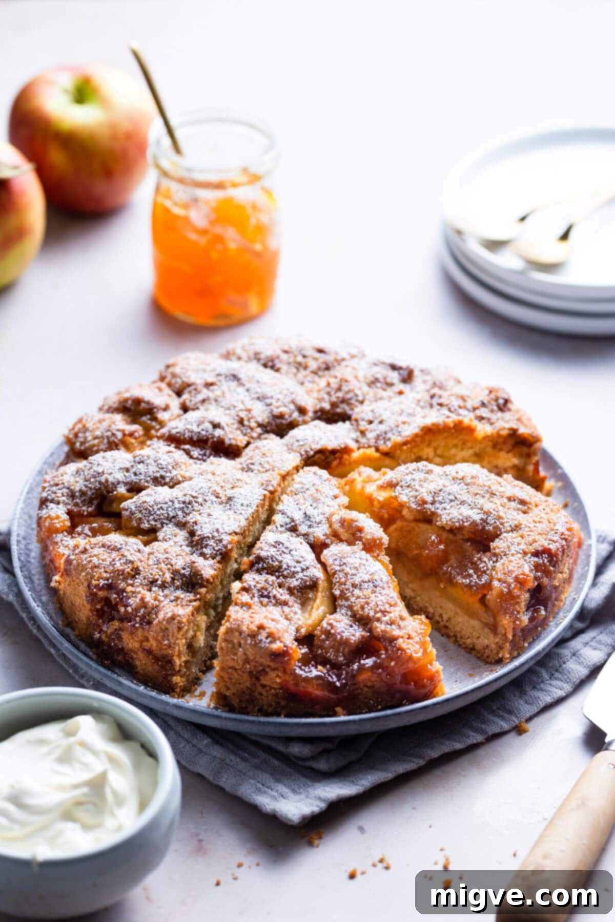 No-Fuss Apple Cake 13 45 degree angle view of an apple cake on a round plate, showing its beautiful golden crust and soft interior