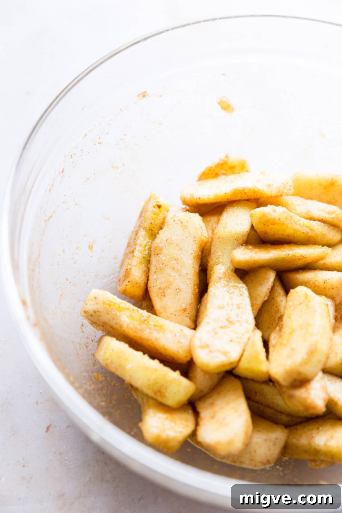 No-Fuss Apple Cake 4 side super close up at sliced apples with sugar and cinnamon, ready for baking