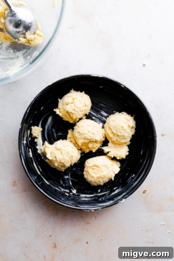 No-Fuss Apple Cake 5 top view of a round baking tin with scoops of cake batter inside, showing initial spreading