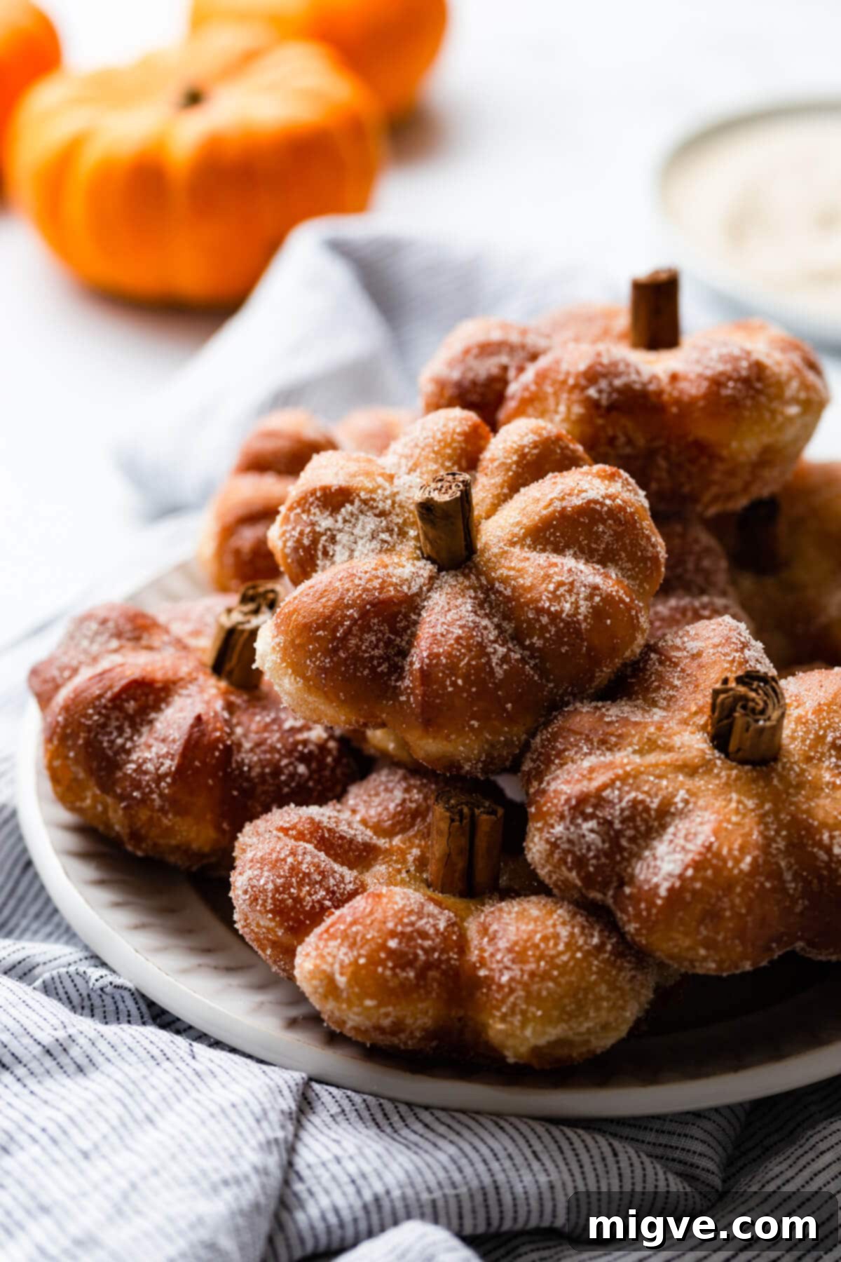 Spiced Pumpkin Doughnut Delights 2 side close up at a plate full of doughnuts shaped like pumpkins