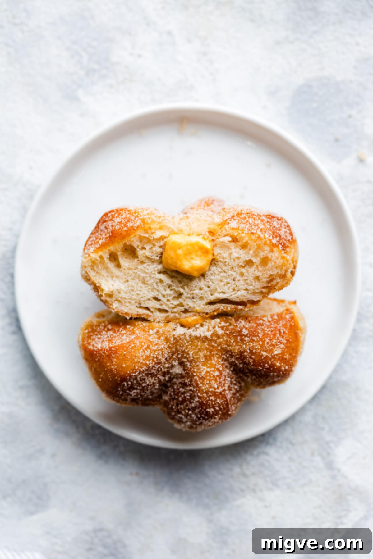 Spiced Pumpkin Doughnut Delights 14 overhead view of a single doughnut sliced in half showing the filling