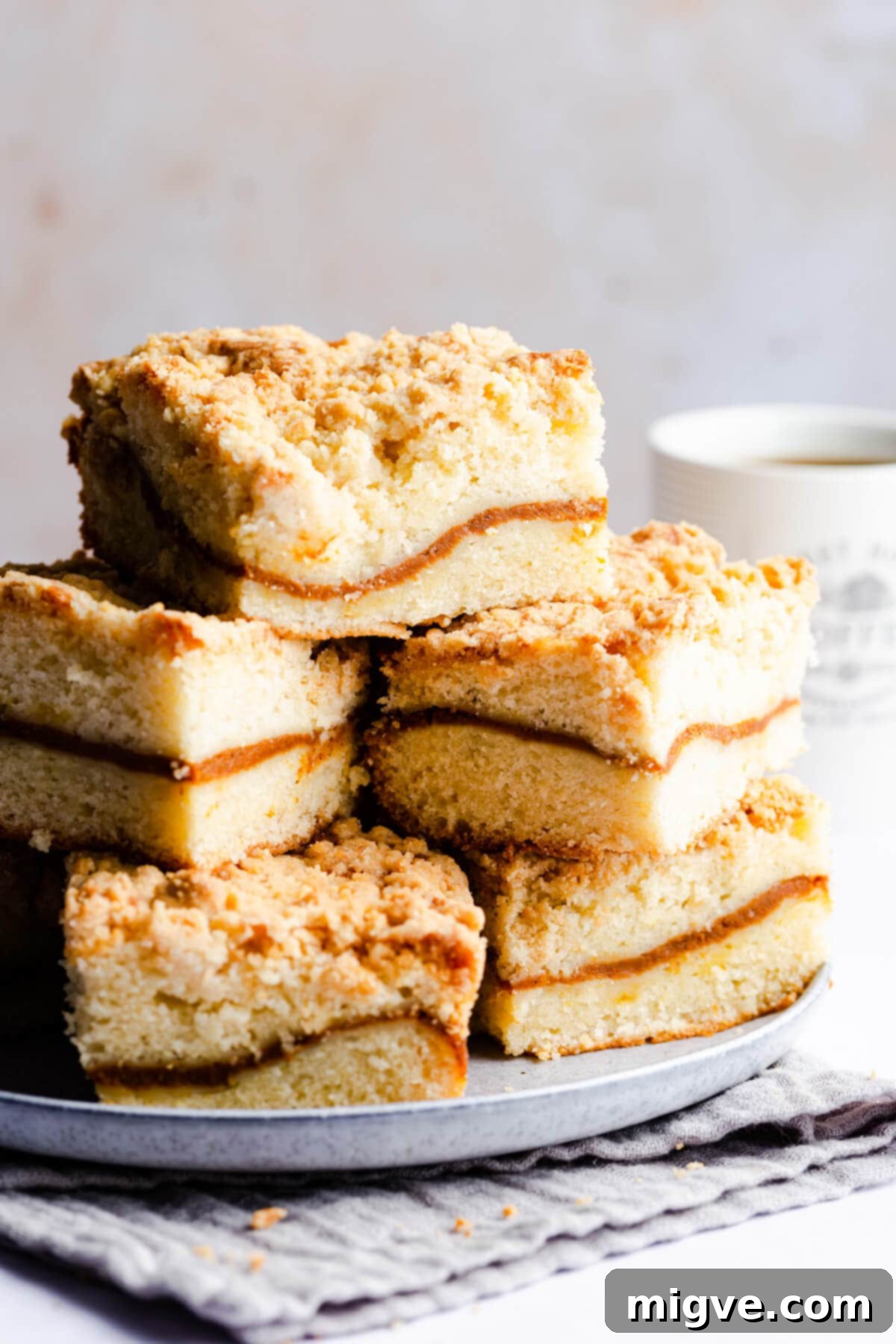 side close up at square pieces of coffee cake piled up on a plate
