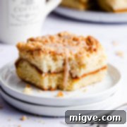 side super close up at a square slice of cake drizzled with cinnamon glaze