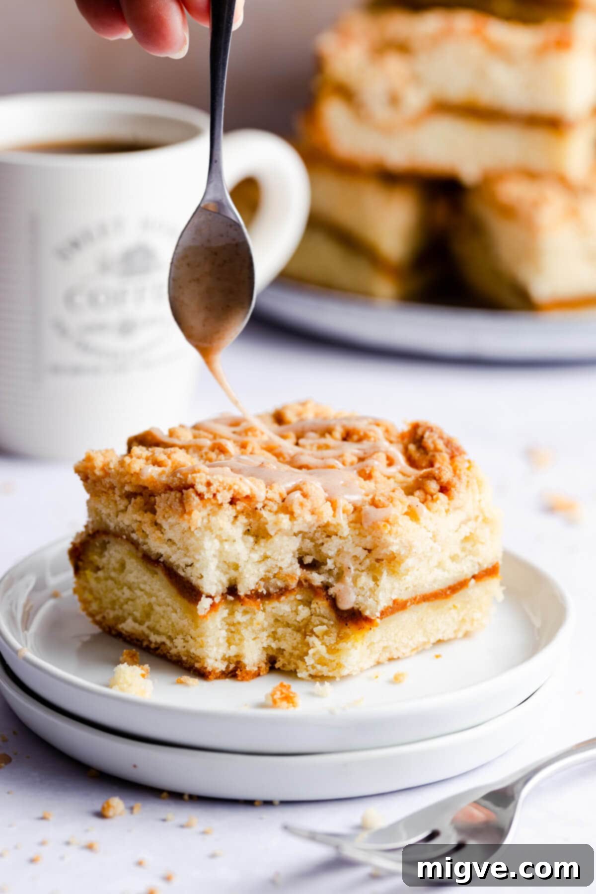 side super close up at a slice of pumpkin coffee cake being drizzled with glaze