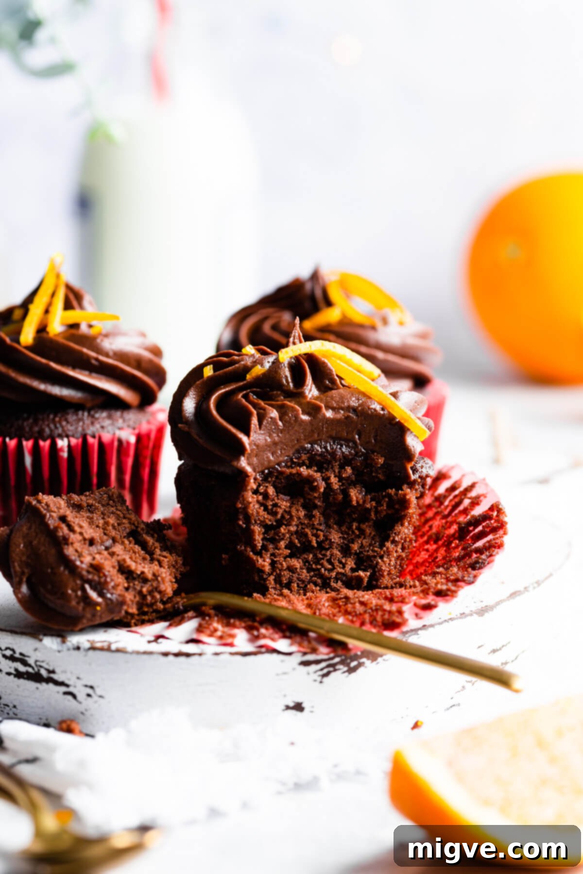 side view close up at a chocolate cupcake with a spoonful of it missing