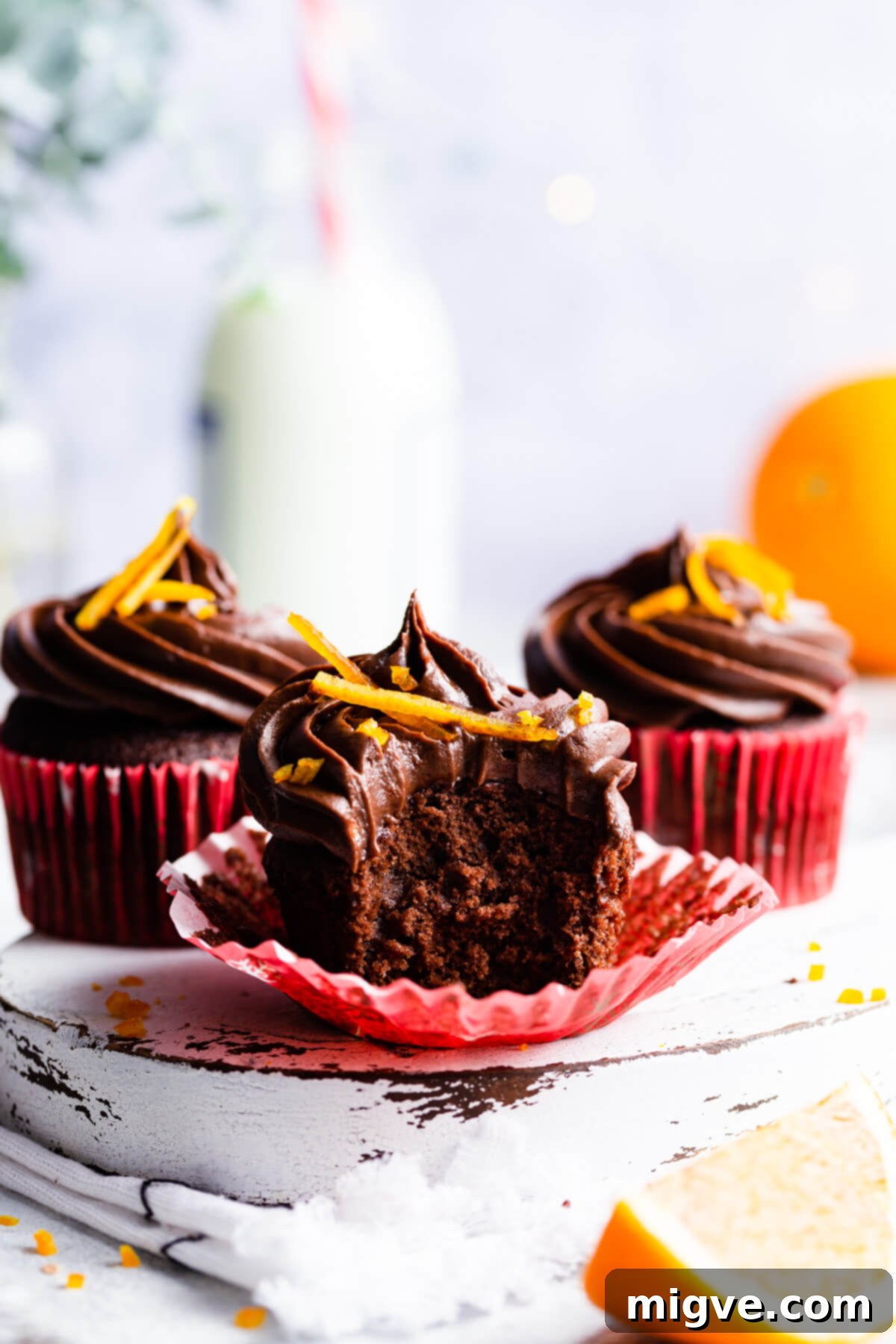 side angle view at an orange cupcake with a bite taken out