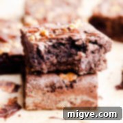 side super close up at a stack of two brownies with top one missing a bite, showing the rich, dense texture
