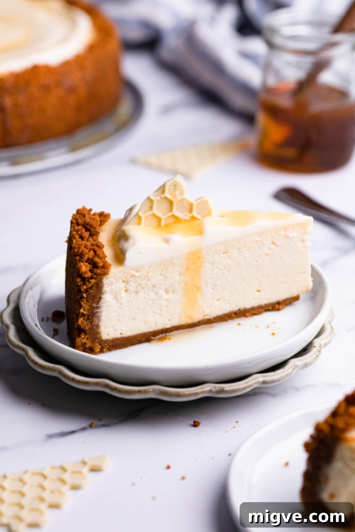 Velvet Honey Cheesecake 9 side close up at a slice of honey cheesecake with elegant salted honey drizzle