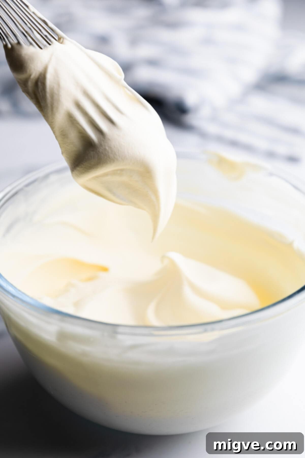 Classic Victoria Sponge 10 close up at a whisk with cream whipped into soft peaks