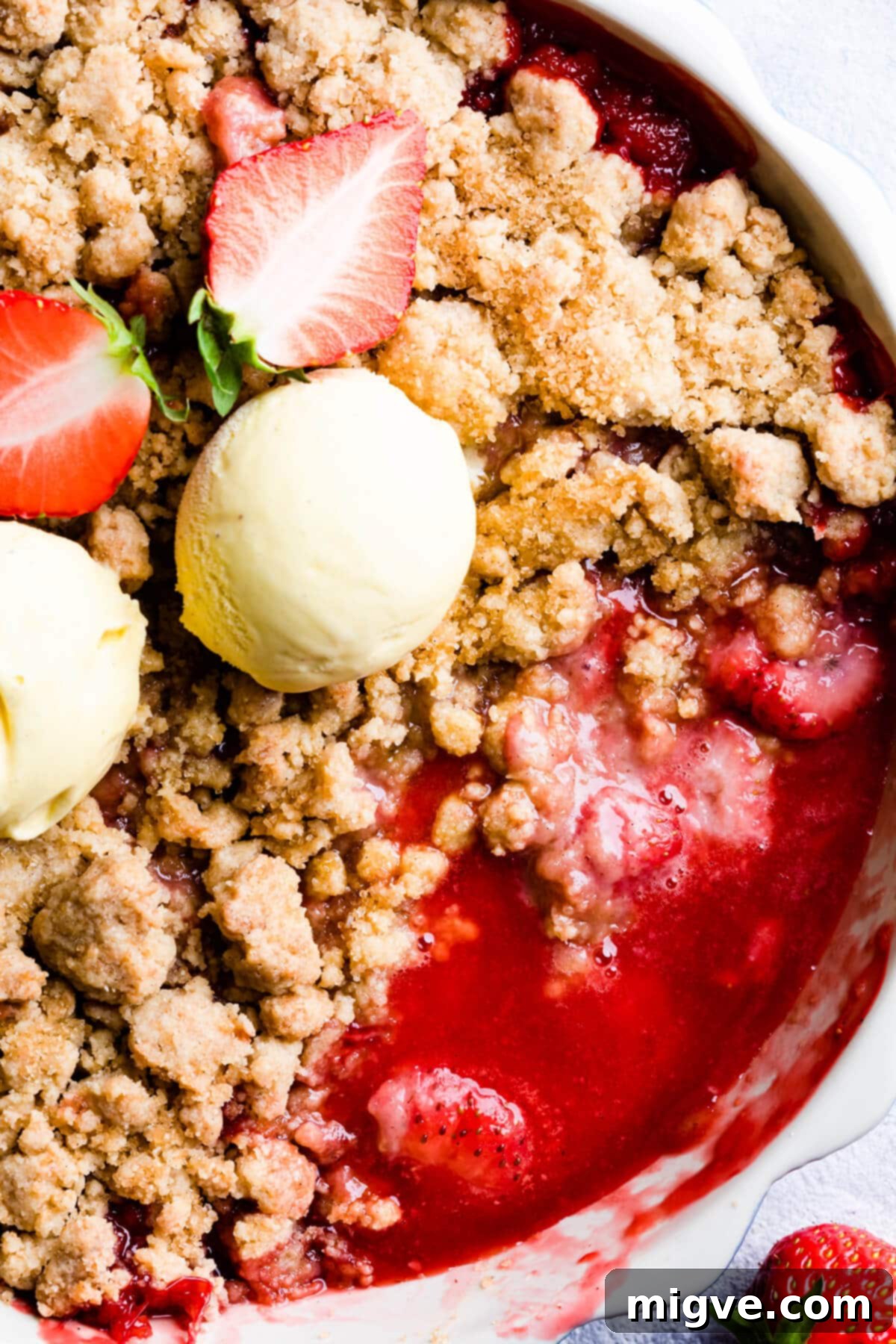 top down close up of a crumble dessert with strawberry sauce underneath