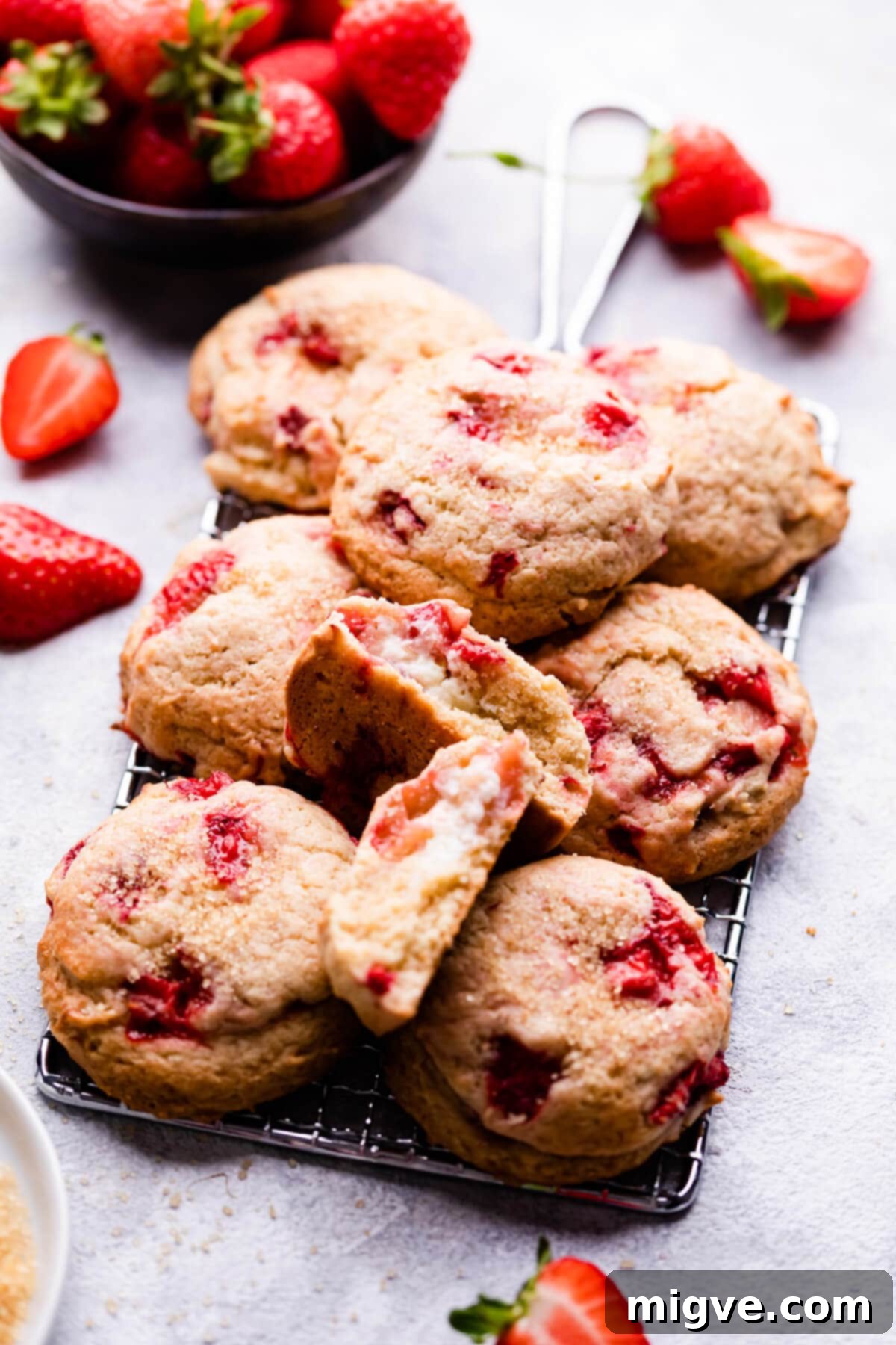 Shortcake Strawberry Cookies 2 Side angle view of strawberry shortcake cookies on a wire cooling rack, showcasing their golden-brown edges and soft centers with visible strawberry pieces.