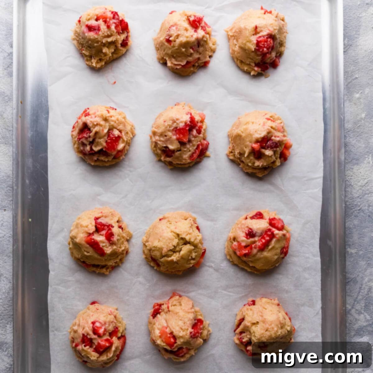 Shortcake Strawberry Cookies 9 Top-down view of perfectly shaped, stuffed cookie dough balls arranged neatly on a baking tray, ready for the oven.