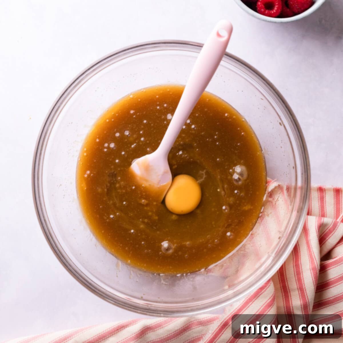 A bowl containing melted butter, sugar, and an egg, ready to be whisked.