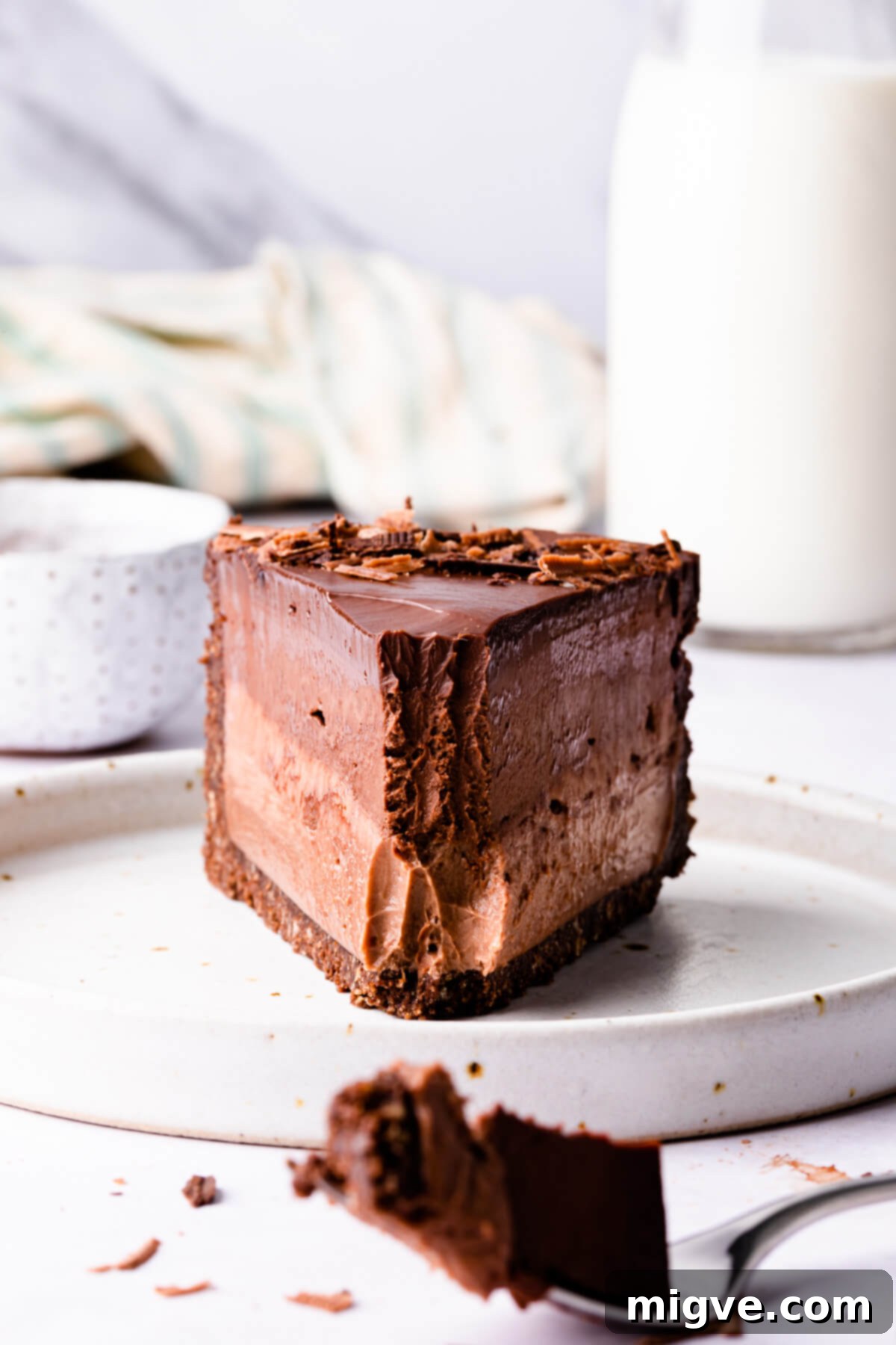 Sinfully Decadent Cheesecake 2 slice of chocolate cheesecake with a front bite missing.