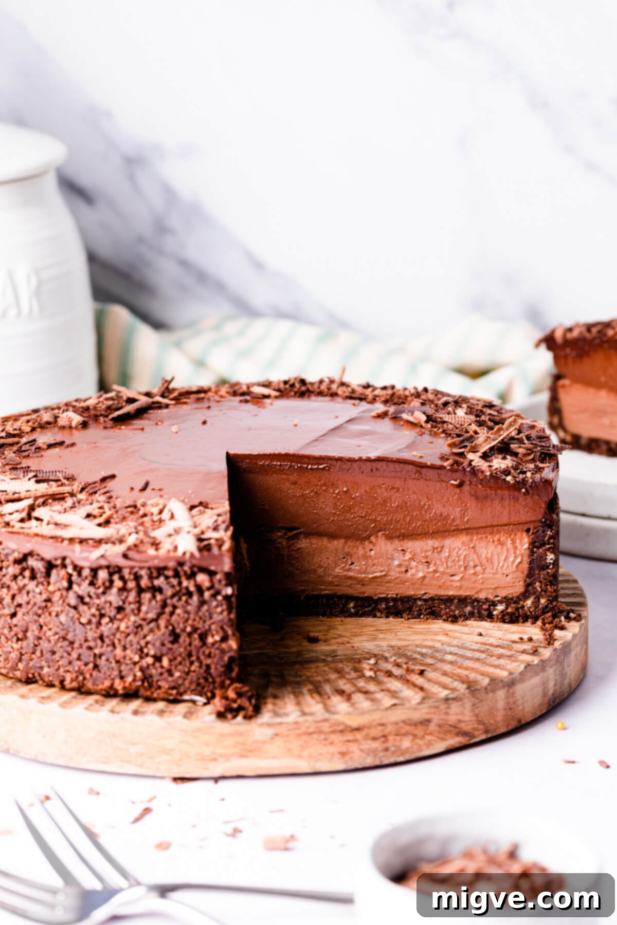 Sinfully Decadent Cheesecake 11 devil's food cheesecake with a slice cut out of it showing two different layers inside.