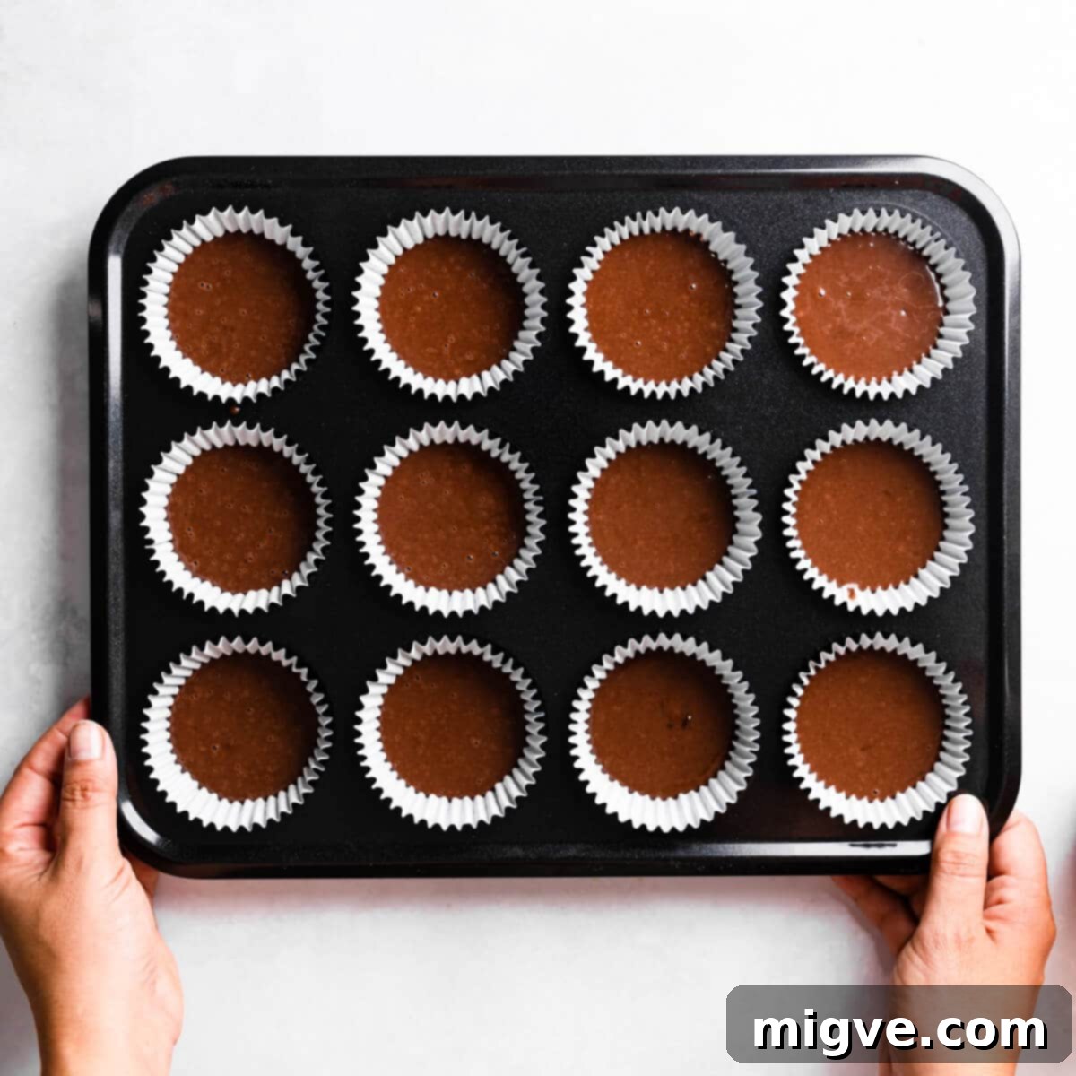 Bandaged Boo Cupcakes 7 Cupcake batter carefully divided into paper cases nestled within a baking tin, ready for the oven.
