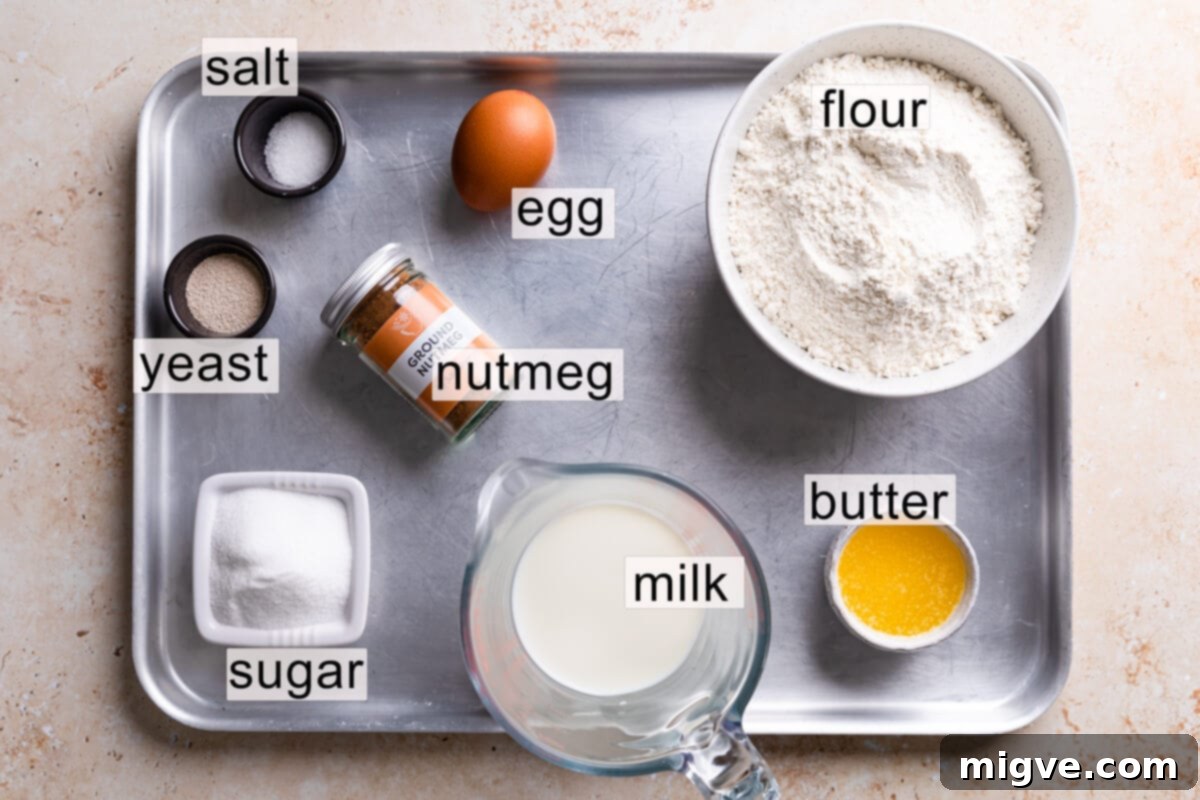 Various doughnut ingredients neatly arranged on a metal tray, each with a clear text label indicating its purpose.