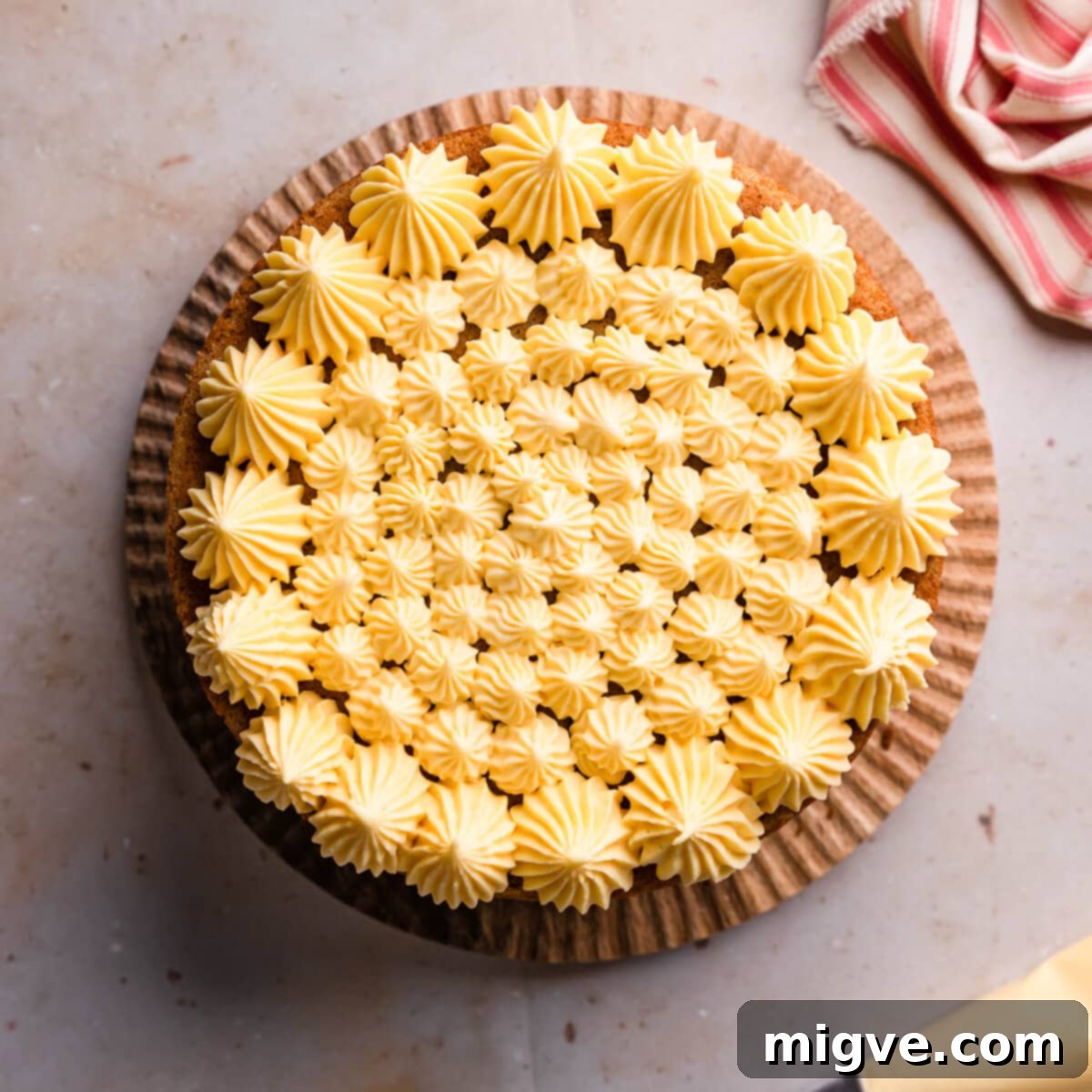 top layer of apple crumble cake with buttercream piped all over it.