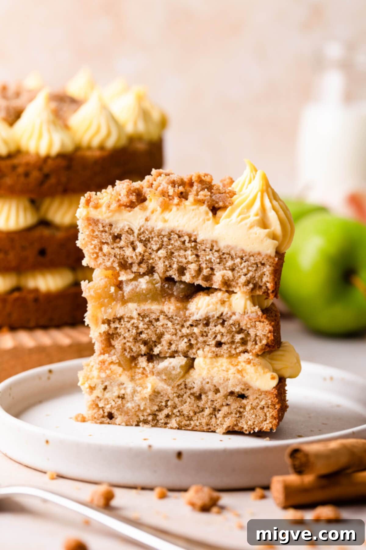 an individual slice of an apple crumble cake on a dessert plate.