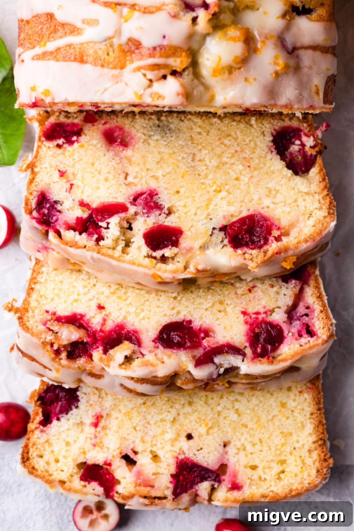 three slices of the orange cranberry loaf with citrus glaze.