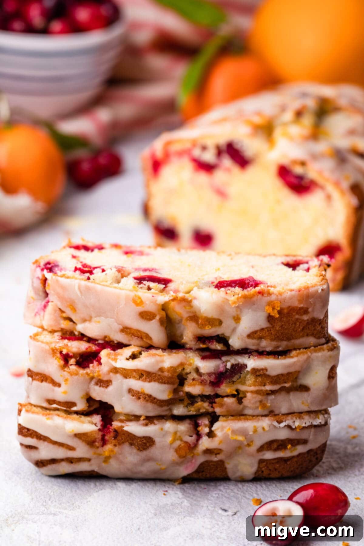 stack of three slices of cranberry bread with orange glaze.