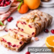 cranberry orange bread with citrus glaze with couple of slices cut off.