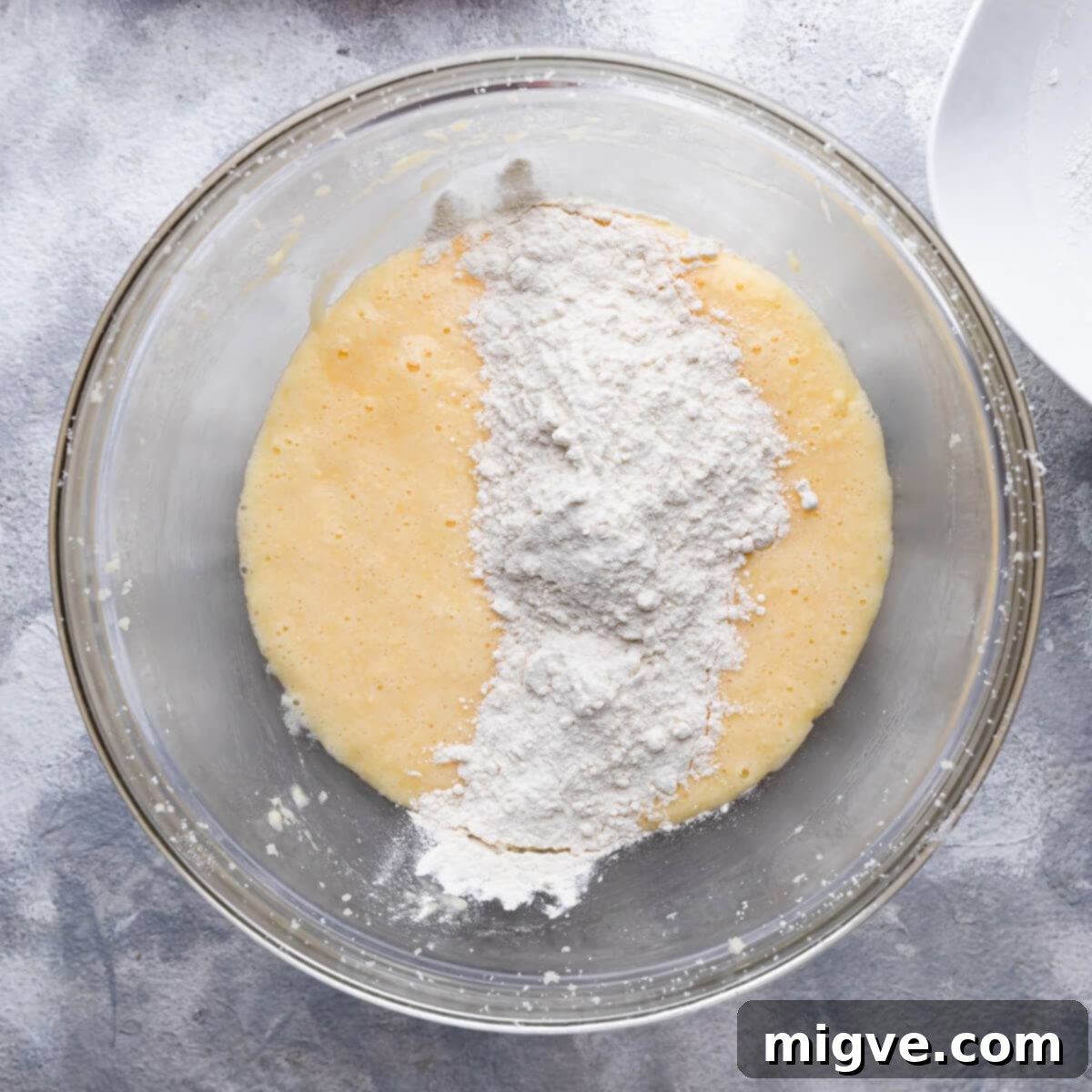 flour added to the bowl with cake batter.
