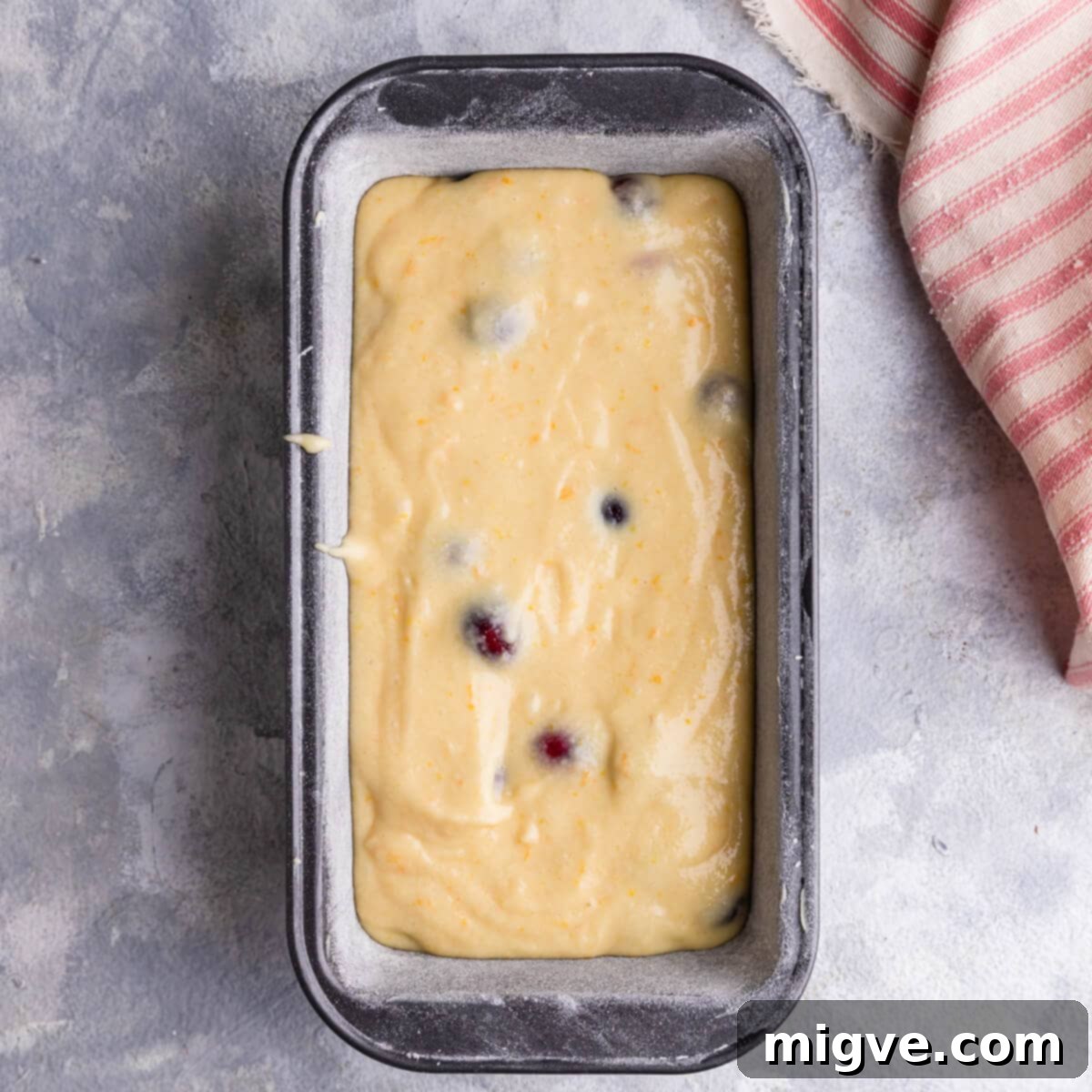 batter for the orange cranberry loaf in a loaf tin.