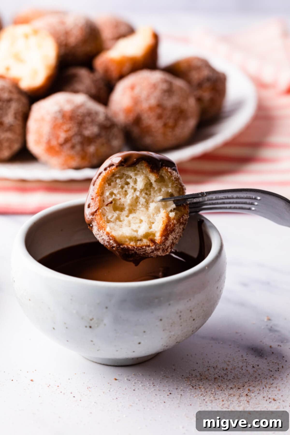 chocolate dipped tofu doughnut with bite taken out of it.