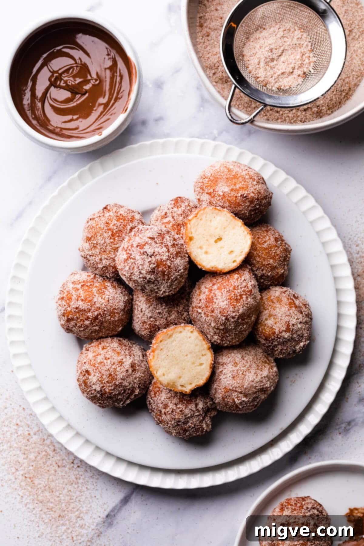 tofu doughnuts on a dessert plate with one doughnut cut in half.
